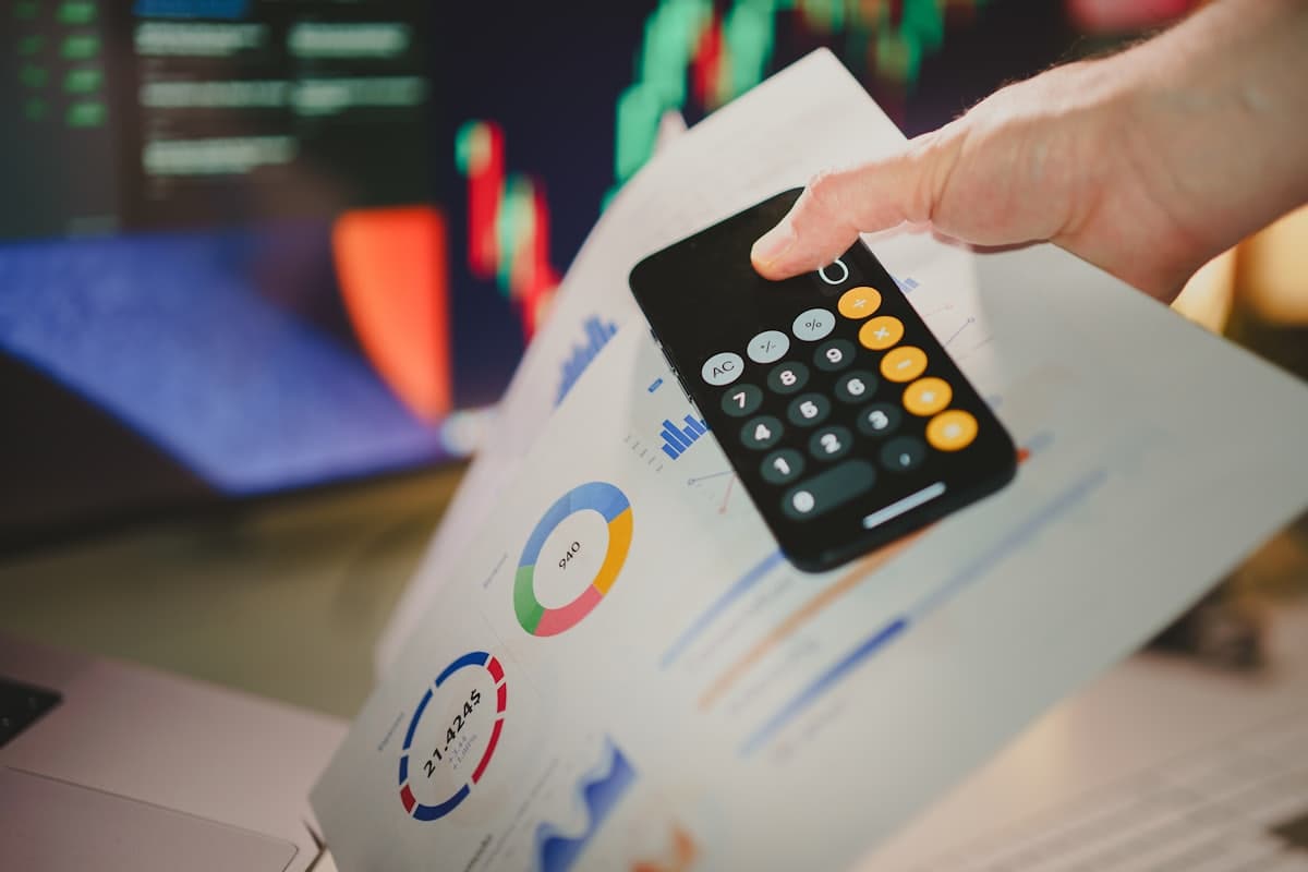 Phone calculator resting on financial charts